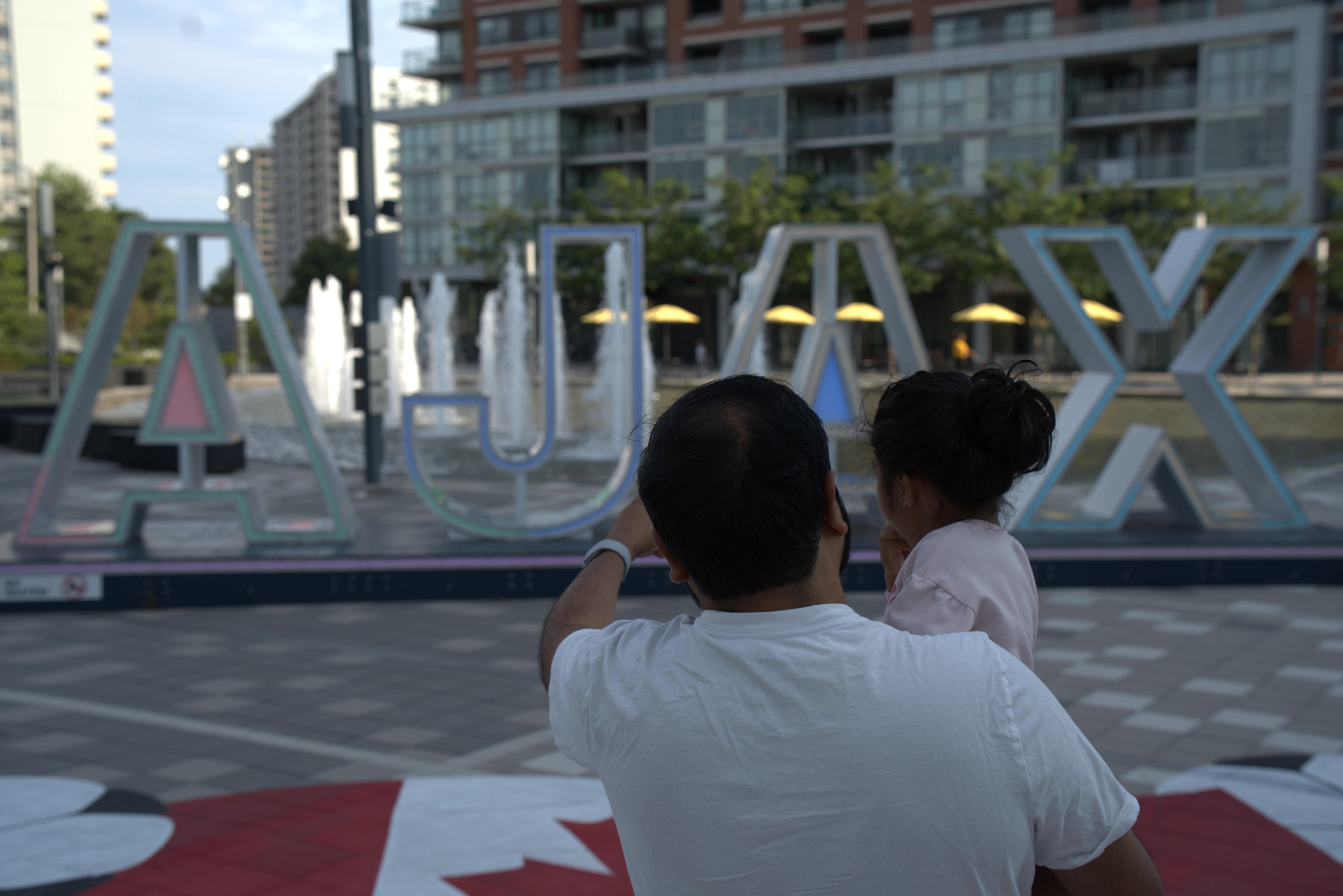 Bhanu holding his daughter at the AJAX sign in Ajax, Ontario